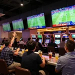 Tỷ Lệ Bóng Đá displayed on screens while spectators place bets in an active casino