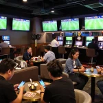 Tỷ Lệ Bóng Đá calculated odds and bets being placed in an upscale sports betting lounge